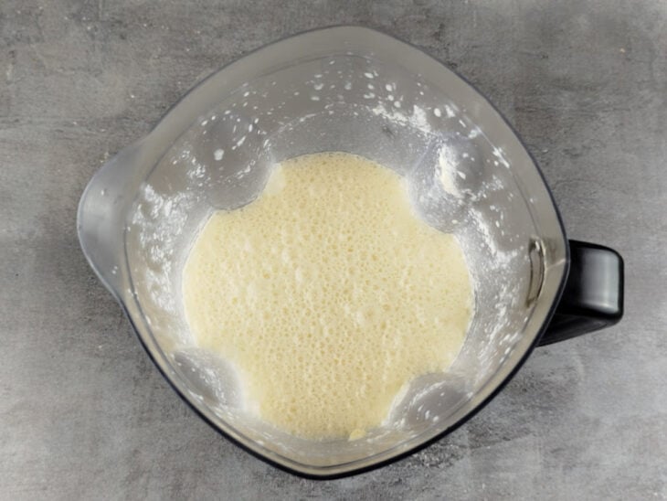 Ingredientes líquidos sendo batidos no liquidificador até formar um creme homogêneo.