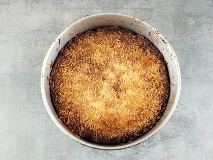 Bolo de coco assando no forno até ficar levemente dourado.