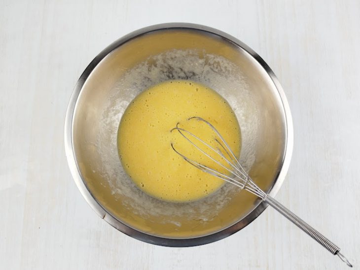 Ovos, leite de coco e óleo sendo misturados em tigela.