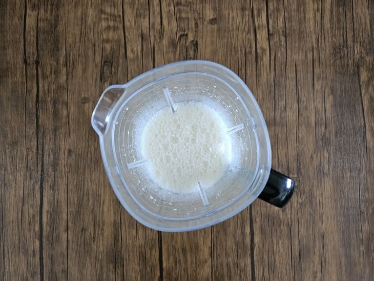 Um liquidificador com ovos, o leite e o açúcar.
