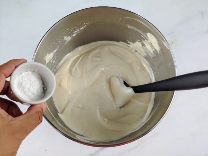 Merengue de claras e fermento em pó adicionados a tigela.