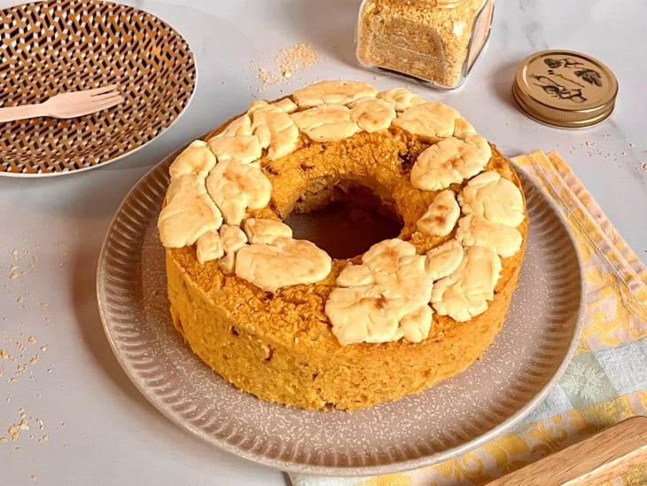 Bolo de cuscuz salgado com requeijão cremoso por cima.