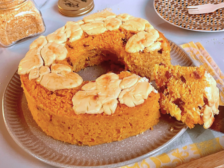 Bolo de cuscuz salgado com um pedaço cortado.