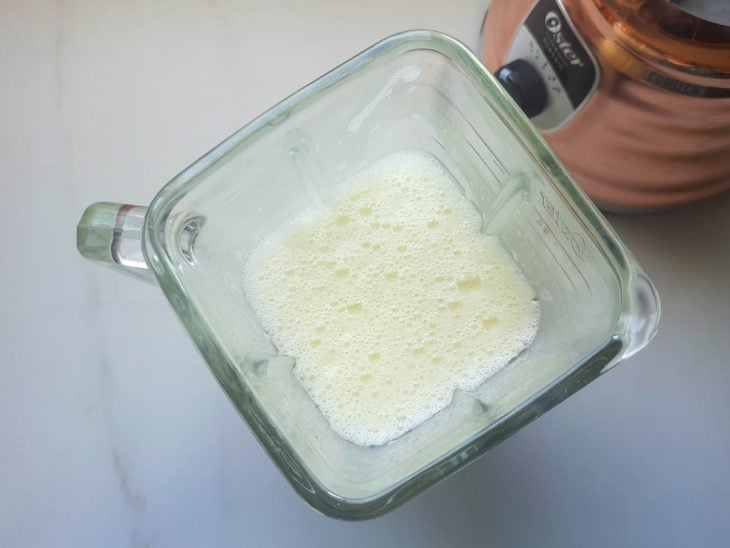 Um liquidificador contendo a mistura de ovos, açúcar, leite e óleo.