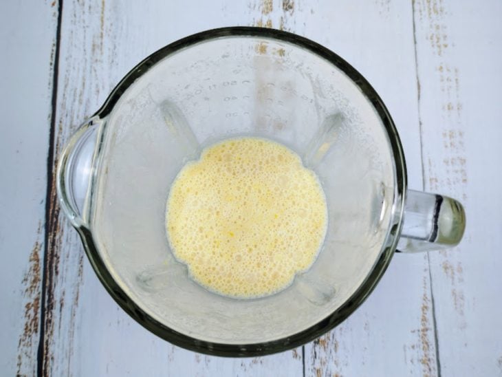 Um liquidificador com milho-verde, leite, leite de coco, ovos e óleo.