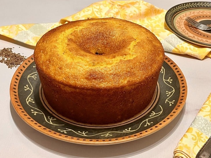 Um recipiente contendo um bolo de fubá com iogurte.