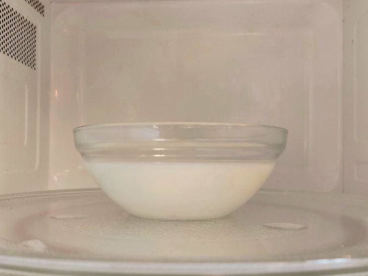 Um recipiente com leite no micro-ondas.