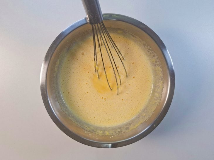 Fubá, fermento e sal sendo adicionados à mistura líquid