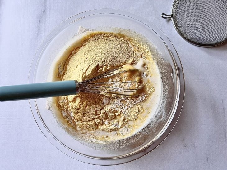 Ingredientes adicionados para serem misturados com fouet na tigela de vidro.