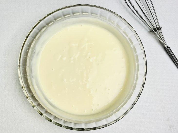 Leite condensado, creme de leite e suco dos limões misturados em uma tigela de vidro.