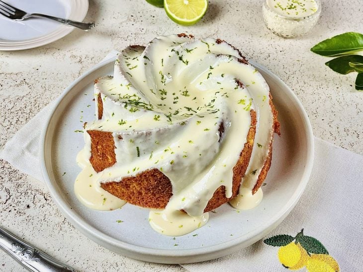 Bolo de iogurte com limão pronto para consumo sobre uma boleira.