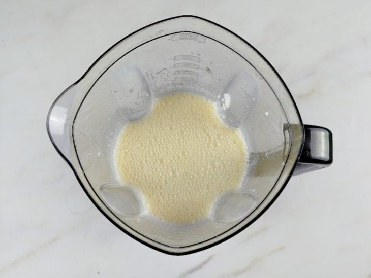 Um liquidificador com ovos, óleo, manteiga, leite, iogurte natural e açúcar.