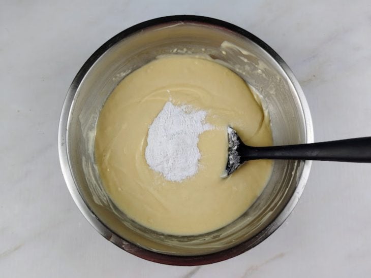Iogurte natural, farinha e fermento adicionadas ao recipiente.