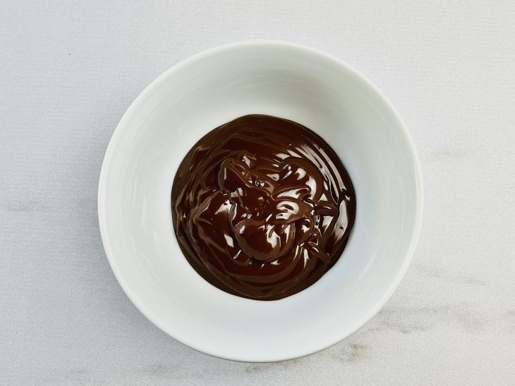 Chocolate derretido num recipiente pequeno.