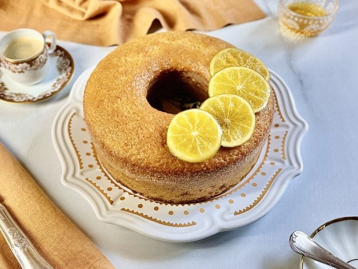 Bolo desenformado e finalizado com rodelas de laranja, pronto para servir.