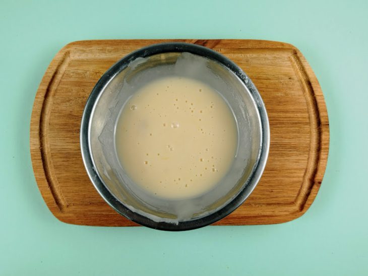 Cobertura preparada em um recipiente redondo de inox.