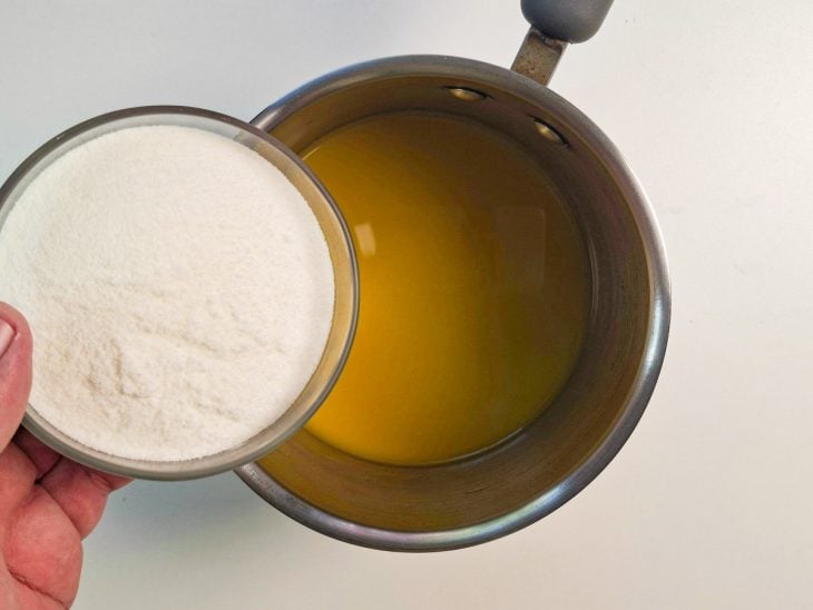 Suco de laranja numa panela e açúcar num pote.