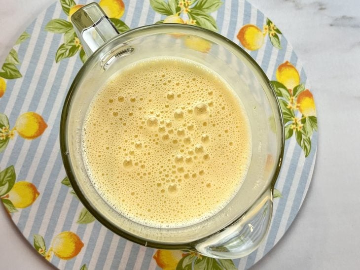 Um liquidificador contendo a mistura de ovos, óleo, açúcar, leite, suco e raspas de limão.