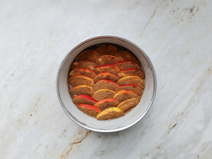 Pedaços de maçã decorando por cima da massa.