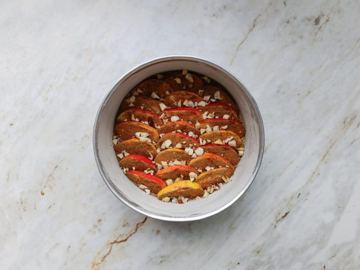 Castanhas polvilhadas por cima da massa e das maçãs.