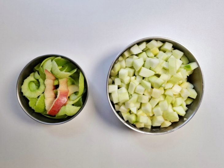 Uma tigela com a maçã picada e outra com as cascas.