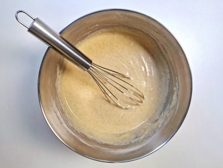 Uma tigela com a massa misturada com um fouet.