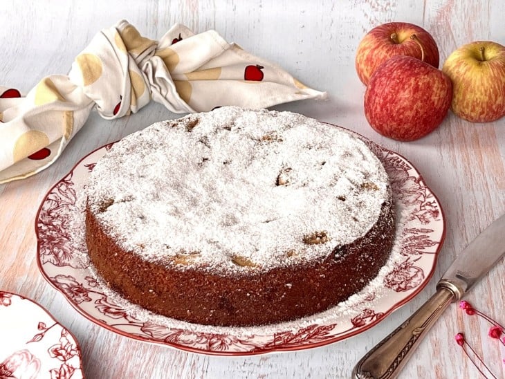 Bolo de maçã fit com uva-passa com açúcar salpicado por cima.