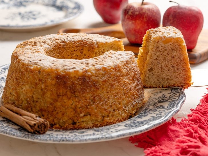 Bolo de maçã desenformado sobre um prato pronto para consumo.