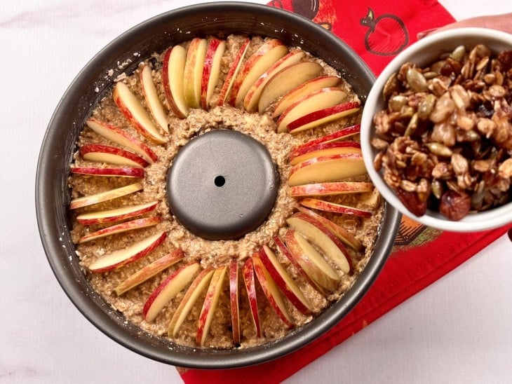 Uma forma contendo o bolo de maçã nutritivo cru.