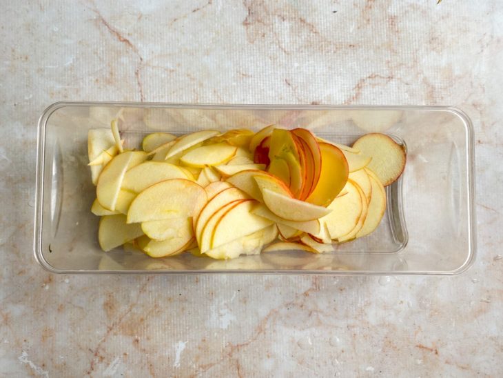 Maçãs em cortes num recipiente.