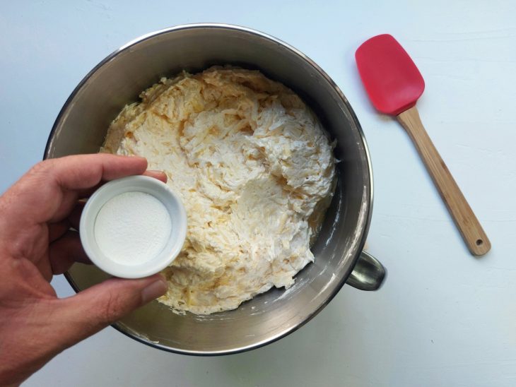 Um recipiente contendo a massa do bolo de macaxeira e a adição de fermento.