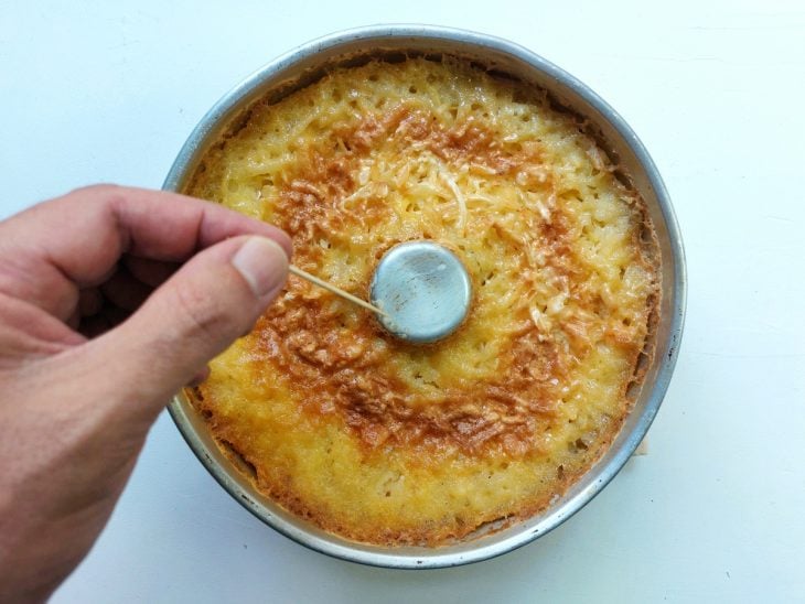 Uma forma com bolo de macaxeira assado.