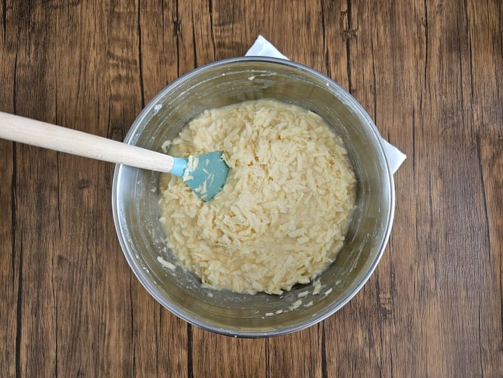 Tigela com ingredientes do bolo de mandioca com coco misturados.