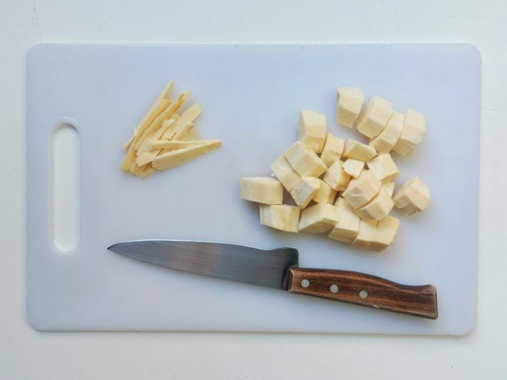 Uma tábua com mandioca picada.