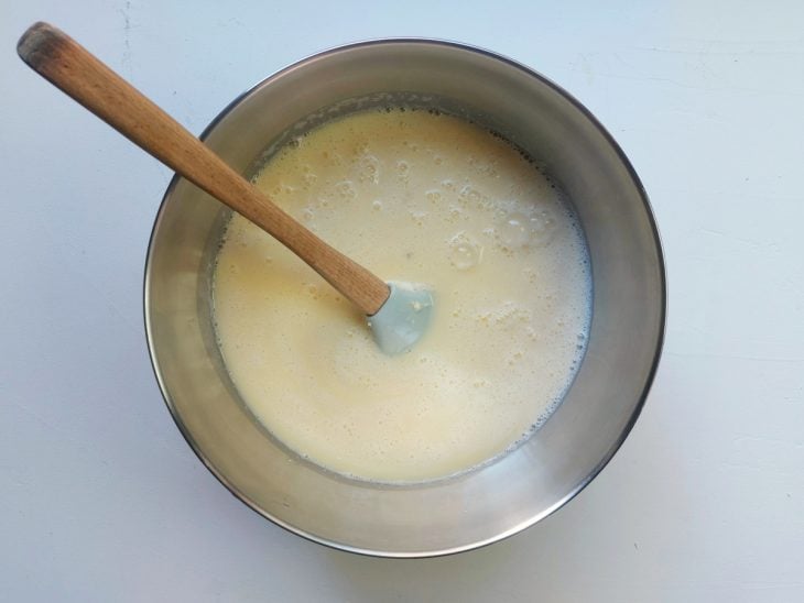 Um recipiente com a mistura dos ingredientes da massa do bolo de mandioca.