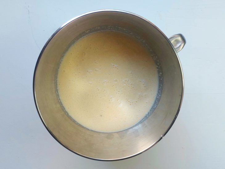 Uma tigela com uma porção da massa do bolo de mandioca.