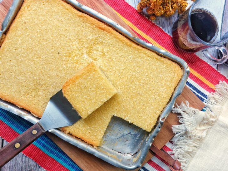 Uma forma com bolo de mandioca no liquidificador.