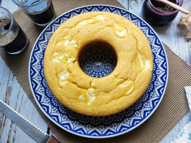 Bolo de milho com requeijão em um prato azul grande.