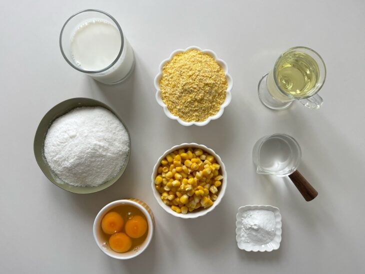Ingredientes separados na bancada com milho escorrido e forma já preparada.