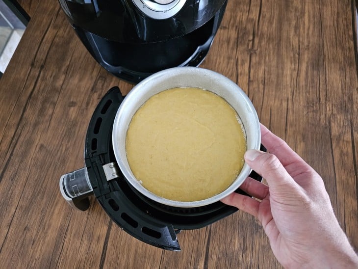 Uma cesta de airfryer com o bolo.