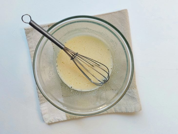 Um recipiente com a mistura de ovo e açúcar.