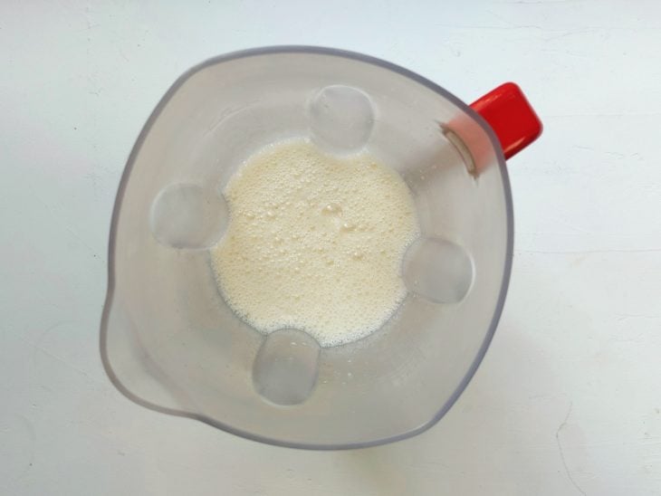Um recipiente contendo a mistura de leite condensado, leite, gemas e amido de milho.