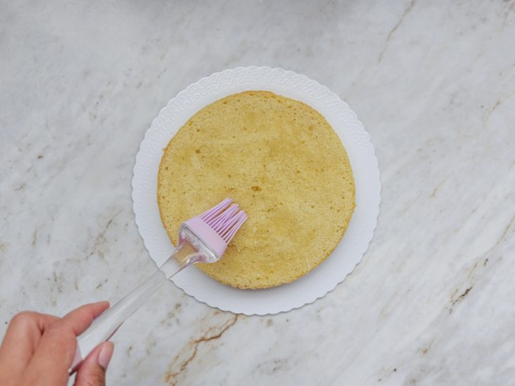 Calda sendo pincelada no bolo.