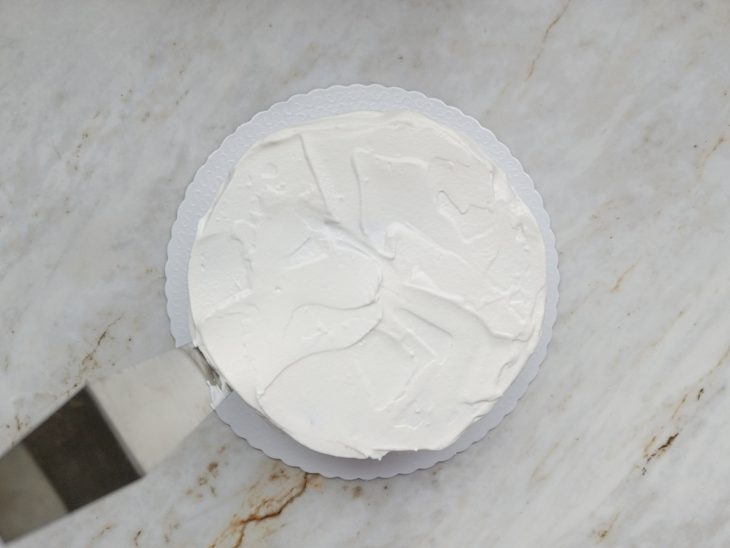 Espátula dando acabamento nas laterais do bolo.