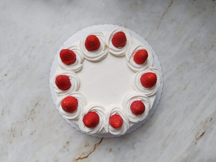 Bolo decorado com chhantilly e morangos.