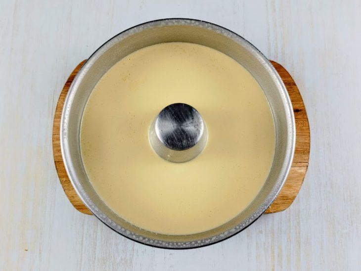 Numa forma untada, a mistura despejada do liquidificador.