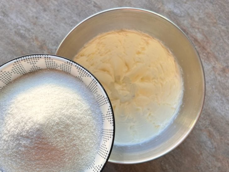Manteiga e açúcar de confeiteiro batidos na batedeira.