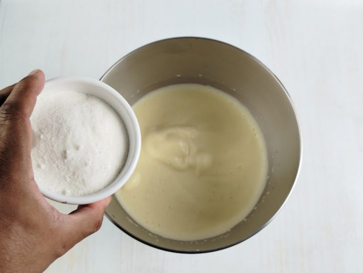 Açúcar adicionado na tigela com ovos batidos.