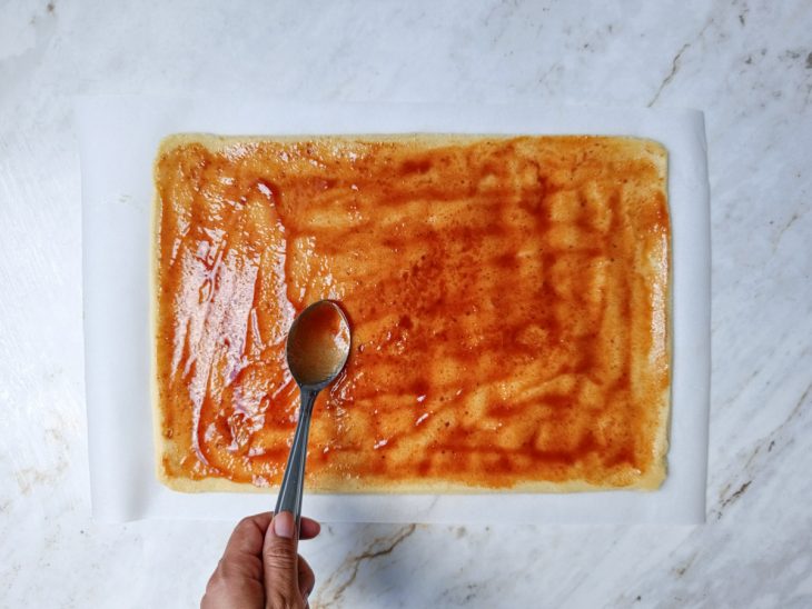 Recheio de goiabada sendo espalhado sobre a massa.