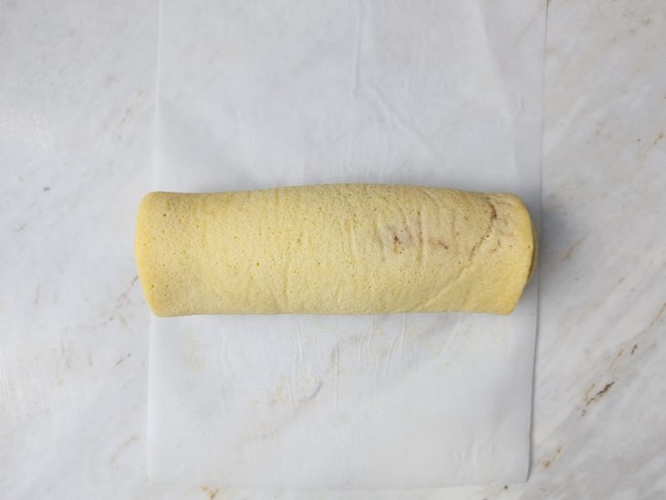 Massa enrolada sobre uma folha de papel-manteiga.